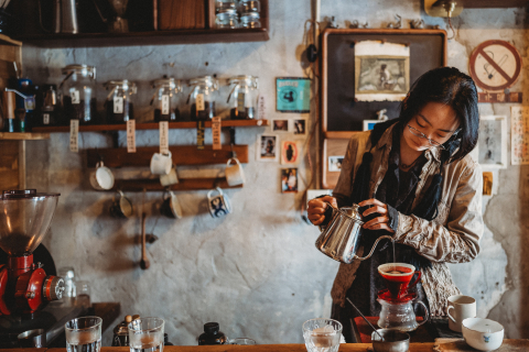 A lifestyle photographer took a picture at Coffee time, M Cafe in Beijing, China of a woman pouring hot water over tea for a business portrait session.