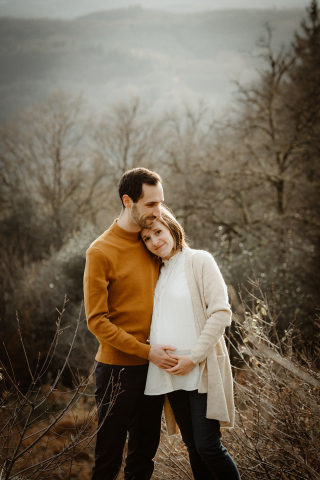 In Limoges, France, during a maternity session, they lovingly touch the woman's pregnant belly as part of a lifestyle image captured for their family.